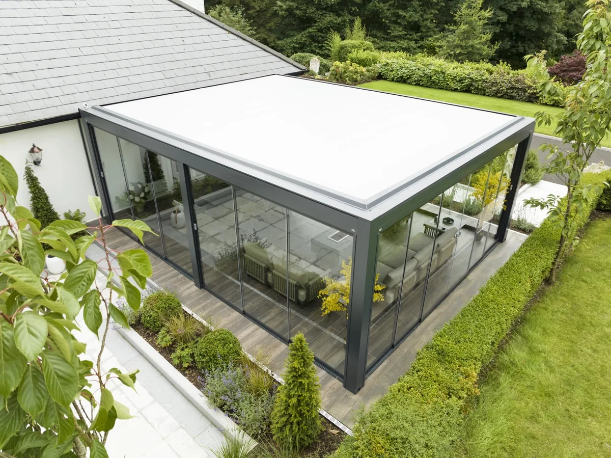 Pergola in un giardino con chiusure panoramiche KE Line Glass trasparenti